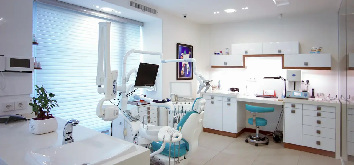 Consultório odontológico com cadeira, equipamentos e bancada